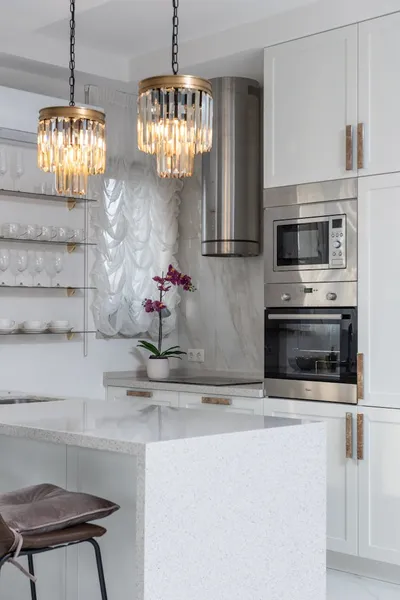 Bright modern kitchen interior with elegant lighting and stainless steel appliances.
